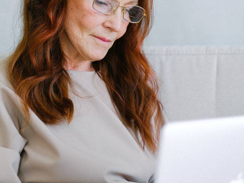 A woman wearing glasses while using a laptop