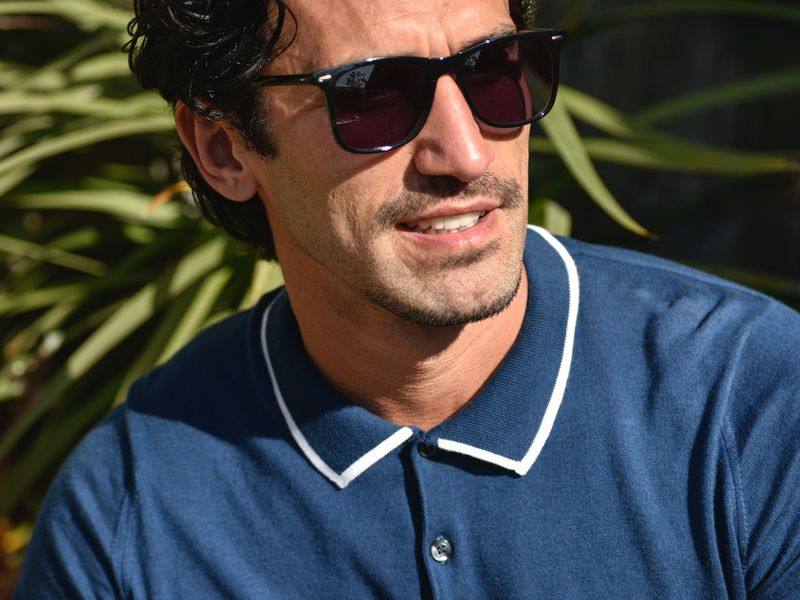 A man wearing glasses with dark lenses in the sun